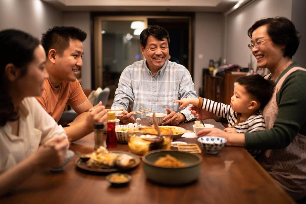 Happy family eating meal together at table.