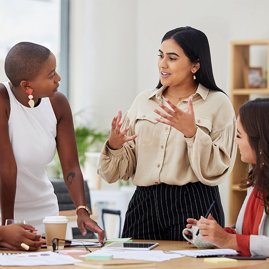 Women at table talking and working together