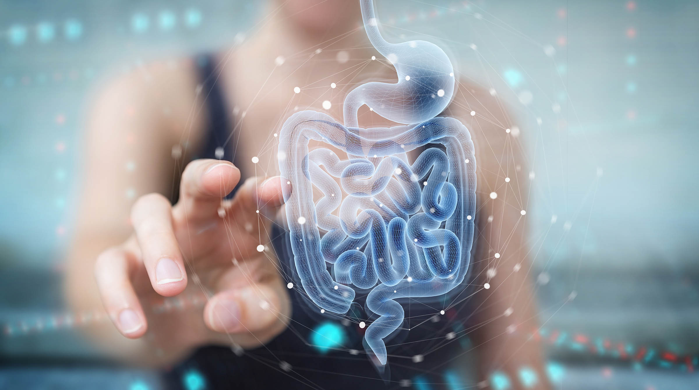 A woman reaching towards a transparent image of the GI tract