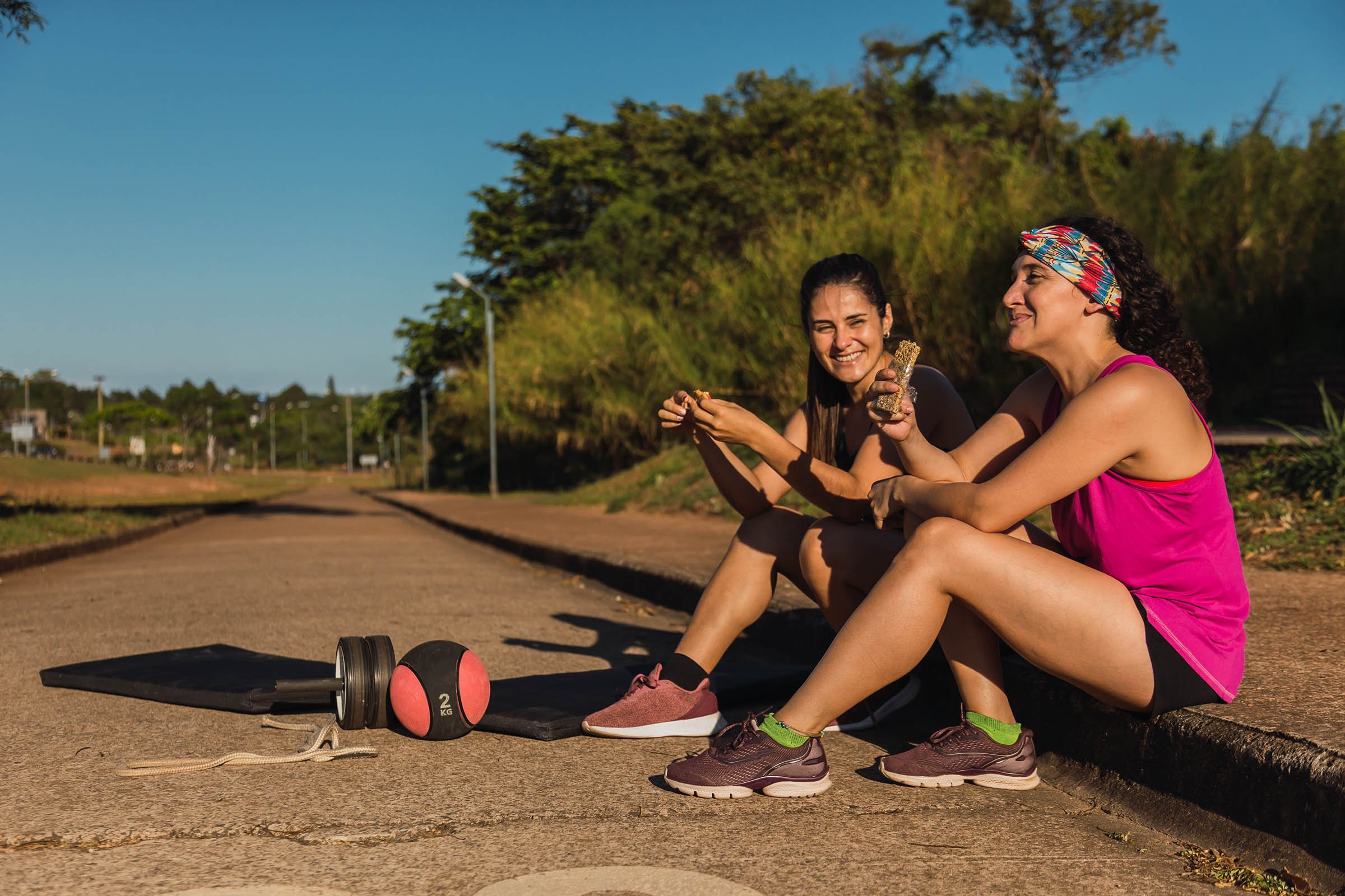 A pair of athletic friends enjoying a snack during a workout