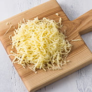 C25 Shredded cheese on cutting board