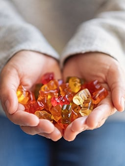 Hands holding fruit gummy snacks