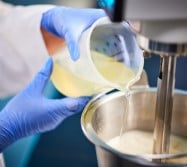 Liquid being poured in a bowl by 2 hands